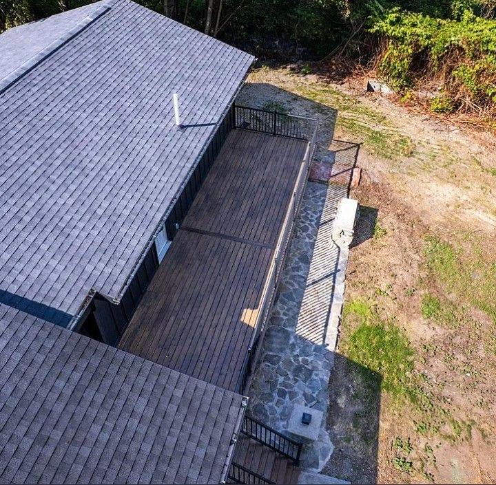 Aerial deck and stone patio by Hammer & Nail Concepts